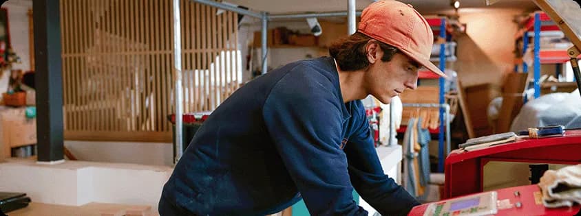 A business owner in their workshop examining materials.
